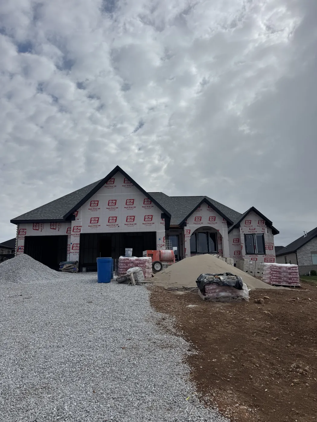 New home under construction with black-framed windows and an arched entry